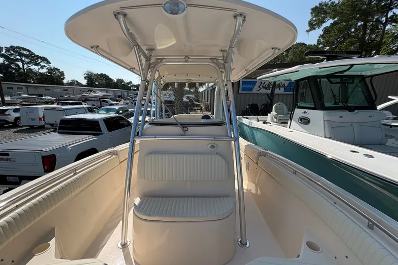Slide: The Image of 2011 Grady-White Canyon 283 boat interior with seating and canopy, parked in a marina. - 8