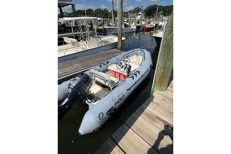 The Image of 2015 Zodiac Bayrunner 500 inflatable boat docked at marina with Yamaha outboard motor. - 0