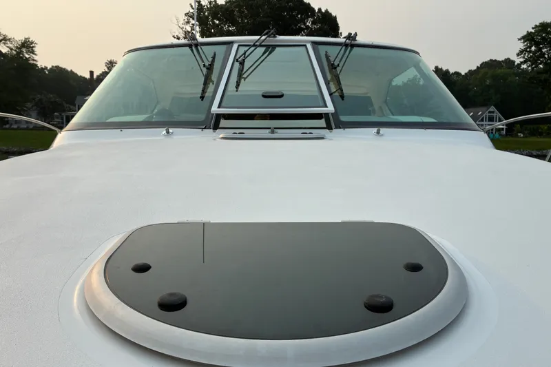 Slide: The Image of 2007 Tiara 3900 Sovran yacht deck with windshield and hatch, surrounded by greenery. - 15