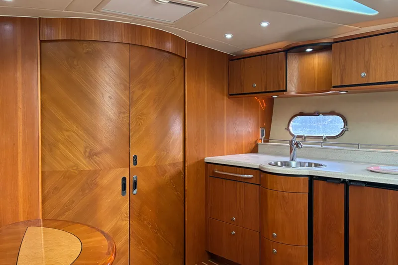 Slide: The Image of Luxurious 2007 Tiara 3900 Sovran yacht interior with wood cabinetry and compact kitchenette. - 51