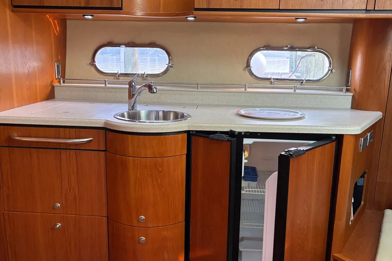 Slide: The Image of 2007 Tiara 3900 Sovran yacht kitchen with wood cabinetry, sink, and open fridge. - 46