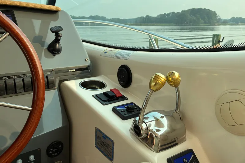 Slide: The Image of 2007 Tiara 3900 Sovran yacht helm with controls and steering wheel, overlooking serene water. - 36