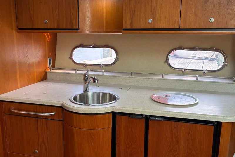 Slide: The Image of 2007 Tiara 3900 Sovran yacht kitchen with wooden cabinets and stainless steel sink. - 45