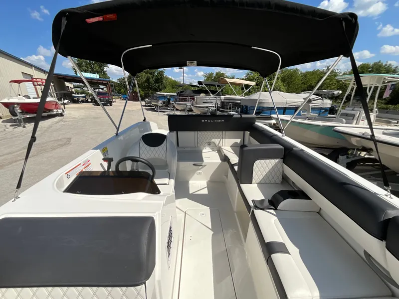 Slide: The Image of The image shows the interior of a 2021 Bayliner DX 2050 with seating and a black sunshade. - 15