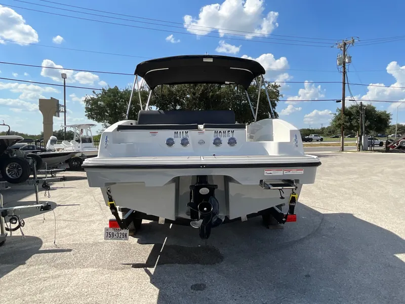 Slide: The Image of The image shows a 2021 Bayliner DX 2050 boat parked on a trailer under a blue sky. - 4