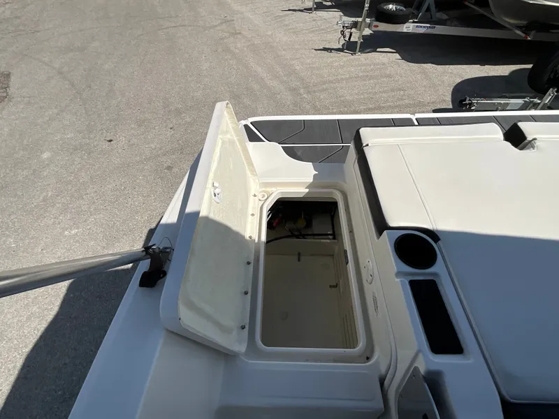Slide: The Image of An open storage compartment on a 2021 Bayliner DX 2050 boat, on a trailer. - 7