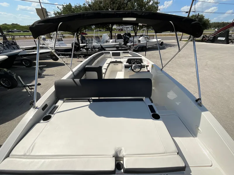Slide: The Image of The image shows a 2021 Bayliner DX 2050 boat with a black sunshade and white seating. - 5