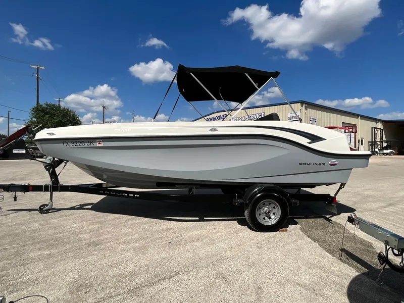 Slide: The Image of A 2021 Bayliner DX 2050 on a trailer under a blue sky. - 3