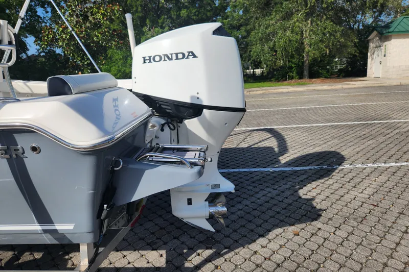 Slide: The Image of 2023 Tidewater 196 CC Adventure boat with Honda outboard motor in a parking lot. - 13