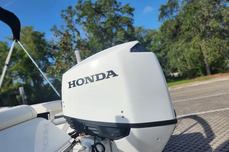 Slide: The Image of 2023 Tidewater 196 CC Adventure boat with Honda outboard motor, parked outdoors. - 20