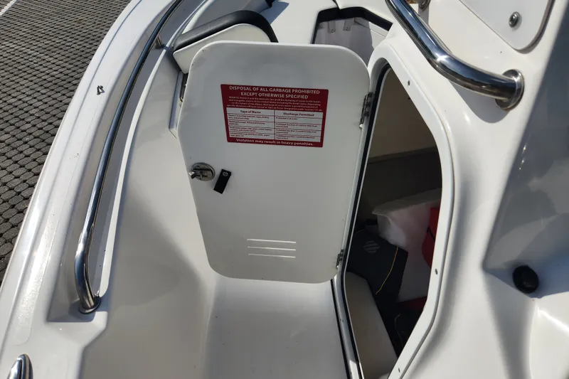 Slide: The Image of 2023 Tidewater 196 CC Adventure boat storage compartment with safety notice on door. - 34