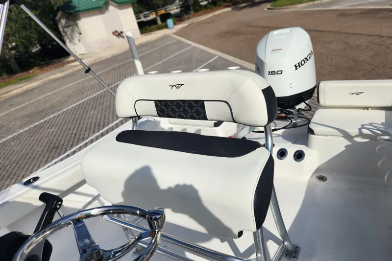 Slide: The Image of 2023 Tidewater 196 CC Adventure boat interior with Honda 150 engine, featuring sleek seating and steering. - 40