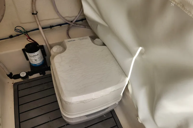 Slide: The Image of 2023 Tidewater 196 CC Adventure boat interior with portable toilet and Shurflo water pump. - 35
