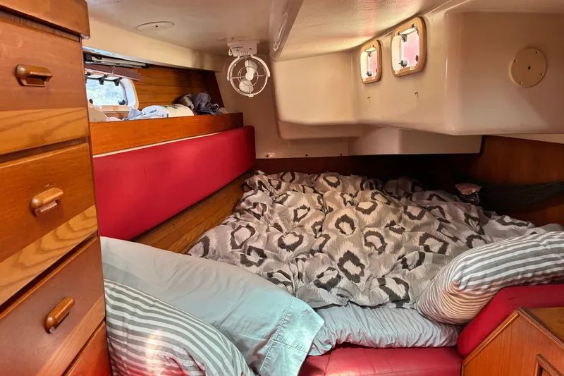Slide: The Image of Cozy cabin interior of a 1989 CAL 39 sailboat with red cushions and patterned bedding. - 23