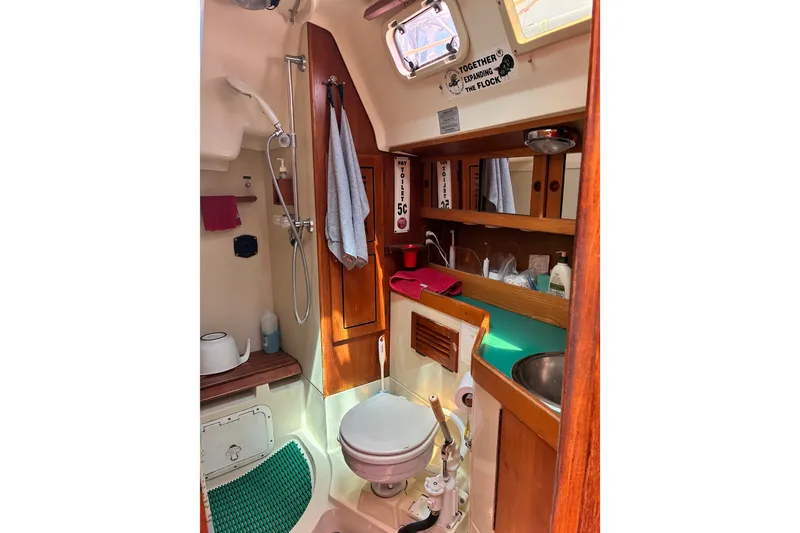 Slide: The Image of Interior of 1989 CAL 39 sailboat bathroom with shower, sink, and wooden cabinetry. - 11