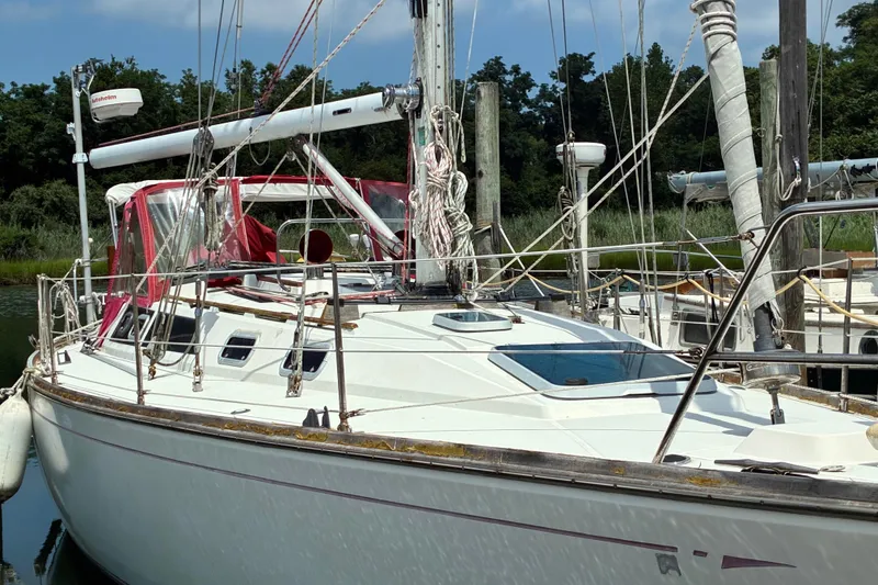 Slide: The Image of Sailboat CAL 39, 1989 model, docked with red canopy and lush greenery background. - 37