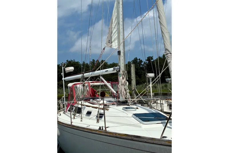 Slide: The Image of 1989 CAL 39 sailboat docked, featuring white hull and red canopy under a clear sky. - 36