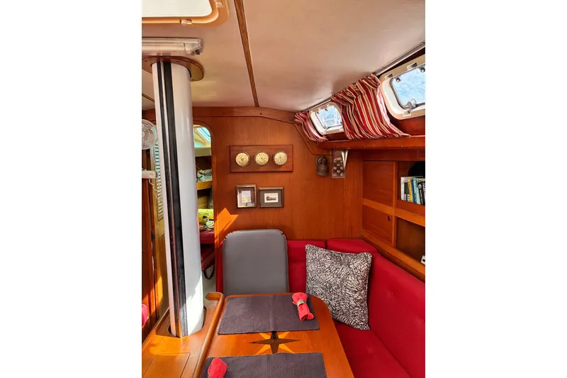 Slide: The Image of Interior of 1989 CAL 39 sailboat with red seating, wooden accents, and nautical decor. - 13