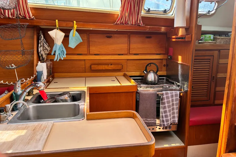 Slide: The Image of Cozy 1989 CAL 39 yacht kitchen with wooden cabinetry, sink, and stove. - 17
