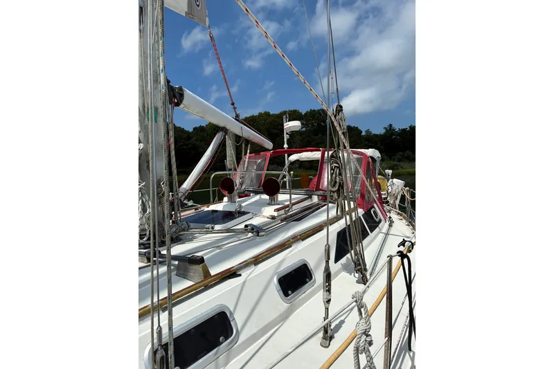 Slide: The Image of 1989 CAL 39 sailboat with red canopy, docked under a blue sky. - 35