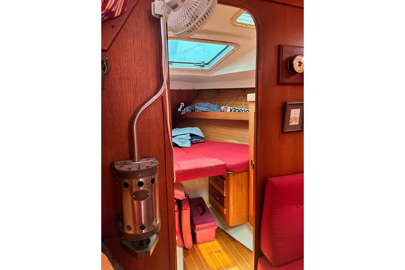 Slide: The Image of Cozy cabin interior of 1989 CAL 39 sailboat with red cushions and wooden finish. - 28