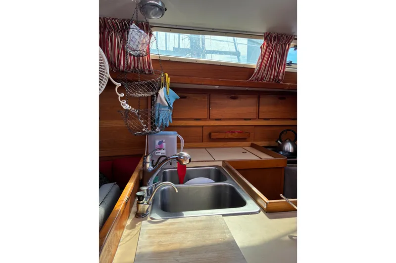 Slide: The Image of Cozy kitchen area in a 1989 CAL 39 sailboat with wooden cabinets and dual sinks. - 40