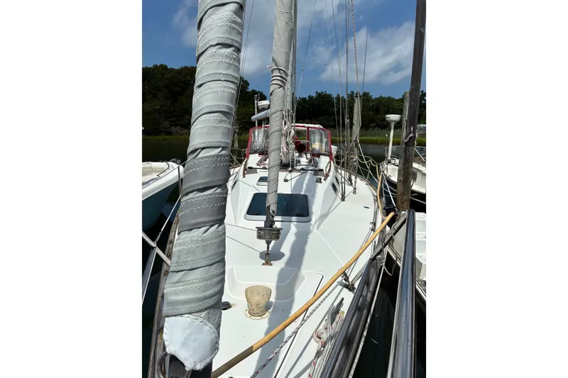 Slide: The Image of Sailboat deck view of 1989 CAL 39 model, featuring wrapped mast and clear sky. - 38