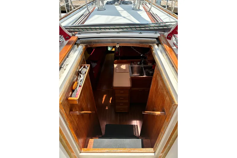 Slide: The Image of Interior view of 1989 CAL 39 sailboat, featuring wooden cabinetry and compact kitchen area. - 29