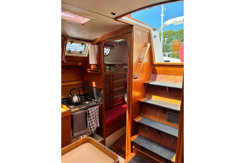 Slide: The Image of Interior of 1989 CAL 39 sailboat with wooden cabinetry and compact kitchen area. - 1