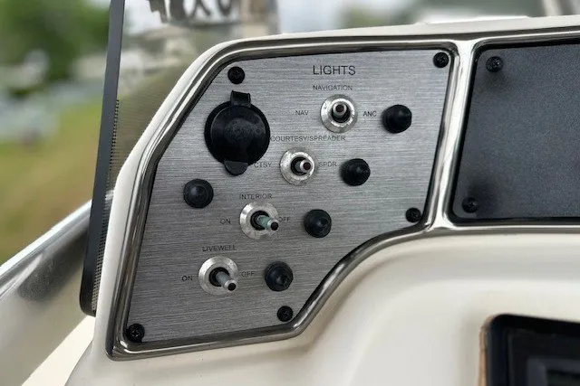 Slide: The Image of Control panel of a 2012 Scout 210 XSF boat, featuring various light switches. - 12