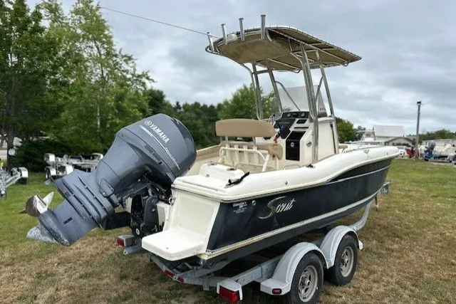 Slide: The Image of 2012 Scout 210 XSF boat with Yamaha outboard motor on a trailer, parked on grass. - 2