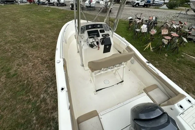 Slide: The Image of 2012 Scout 210 XSF boat with center console and seating, parked on grass. - 16