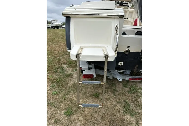 Slide: The Image of 2012 Scout 210 XSF boat with extended swim ladder on grassy area. - 6
