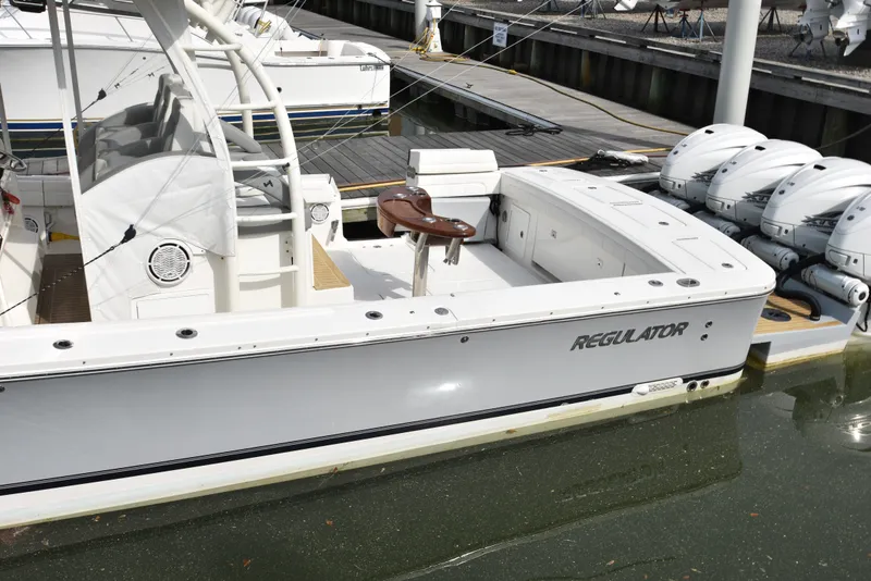 Slide: The Image of A 2019 Regulator 41 FS boat docked. It features four outboard engines and a spacious deck. - 13