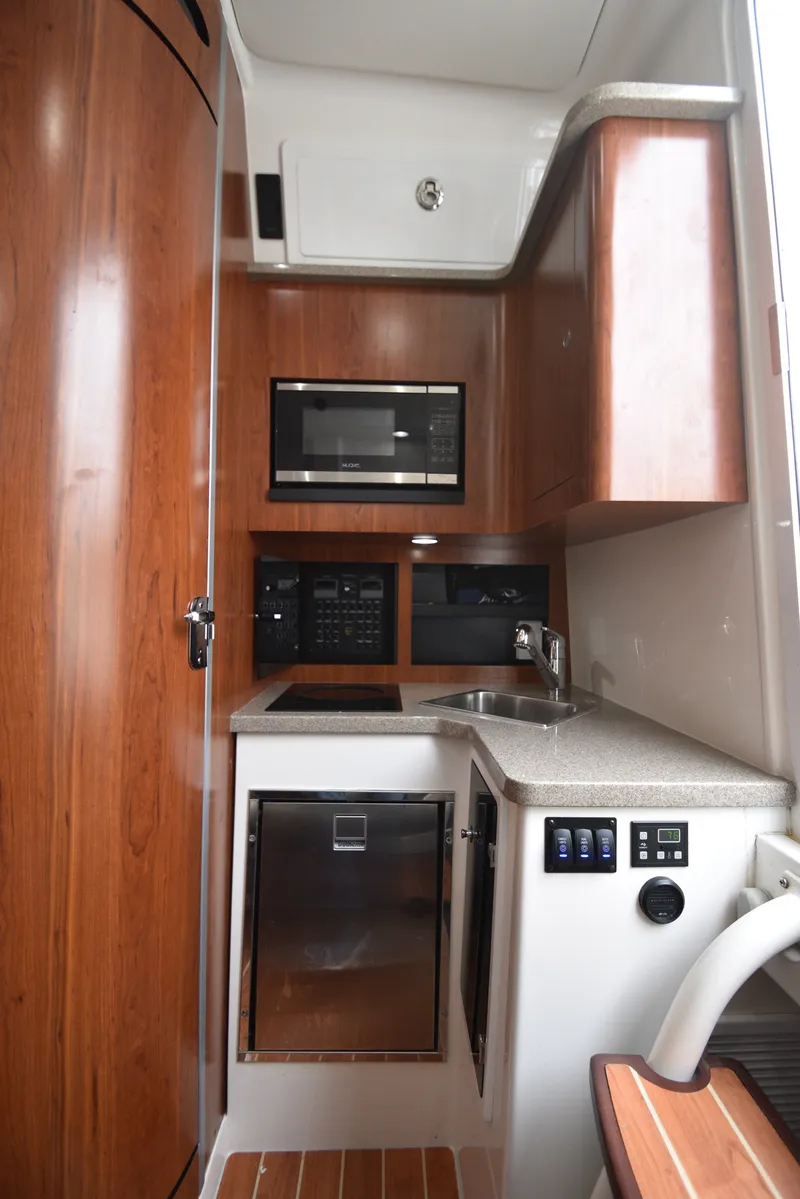 Slide: The Image of The 2019 Regulator 41 FS cabin features a compact galley with wood paneling, sink, and microwave. - 38