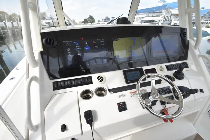 Slide: The Image of The image shows the helm of a 2019 Regulator 41 FS boat with multiple screens and a steering wheel. - 26