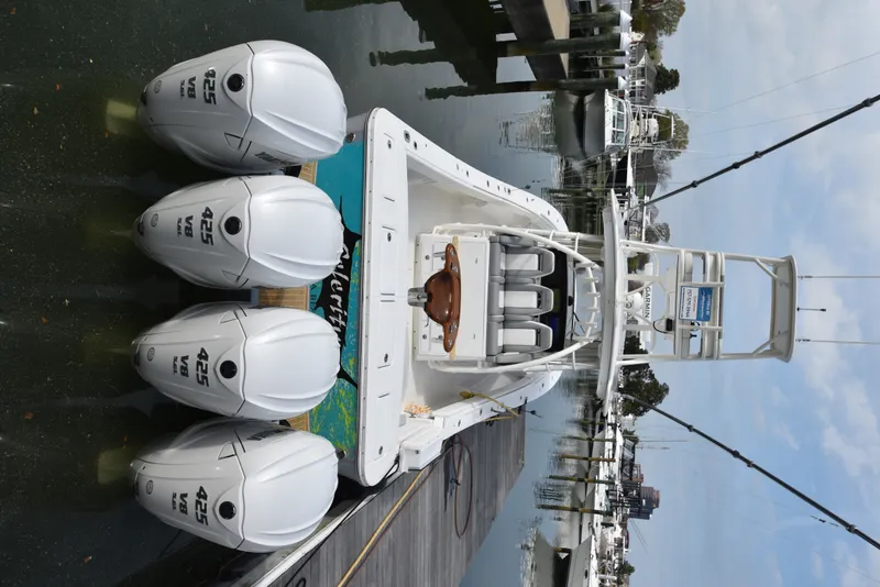 Slide: The Image of A 2019 Regulator 41 FS with four outboard engines docked. The boat features a spacious deck. - 16