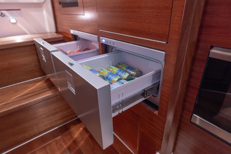 Slide: The Image of 2027 Pursuit S 388 Sport interior with open beverage drawers, showcasing sleek wooden cabinetry. - 30