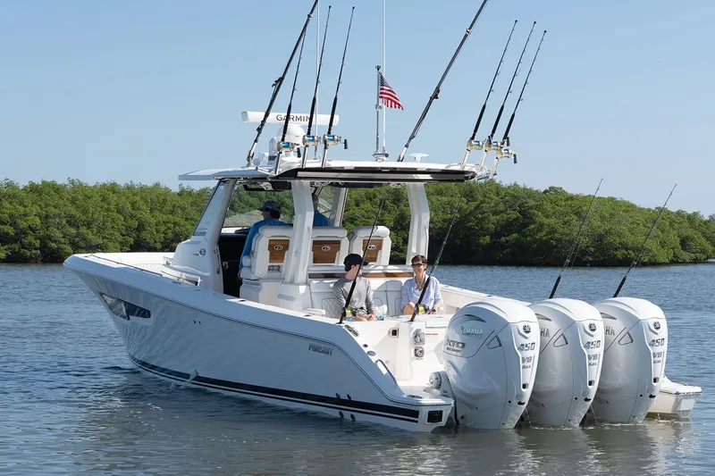 Slide: The Image of 2027 Pursuit S 388 Sport boat with four Yamaha engines on calm water. - 2