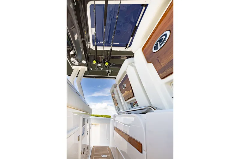 Slide: The Image of 2027 Pursuit S 388 Sport boat interior with fishing rods and wooden accents. - 15