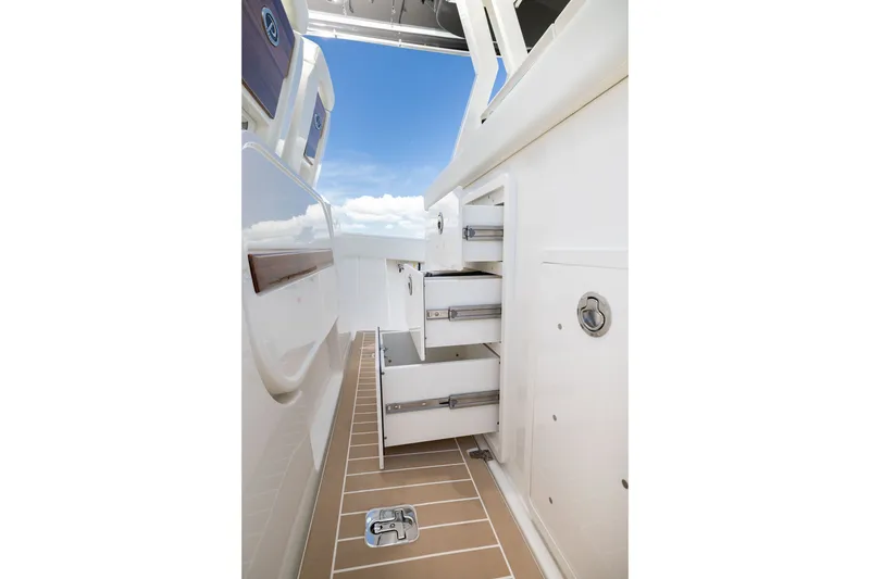 Slide: The Image of 2027 Pursuit S 388 Sport boat interior with open storage drawers and sleek design. - 17