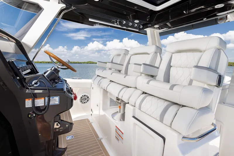 Slide: The Image of 2027 Pursuit S 388 Sport boat interior with luxurious white seating and modern helm. - 12