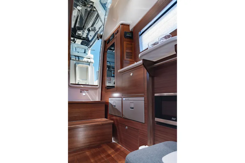 Slide: The Image of Interior of 2027 Pursuit S 388 Sport boat with modern wood finish and appliances. - 29
