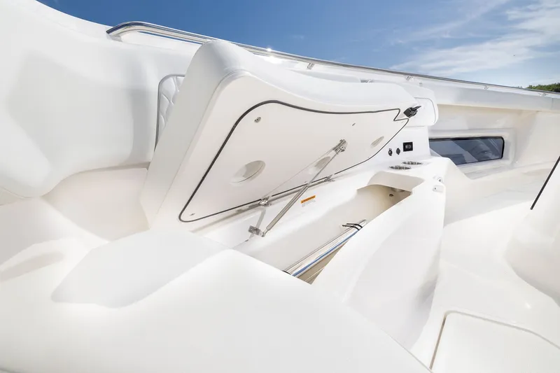 Slide: The Image of 2027 Pursuit S 388 Sport boat interior with open storage compartment under clear blue sky. - 7