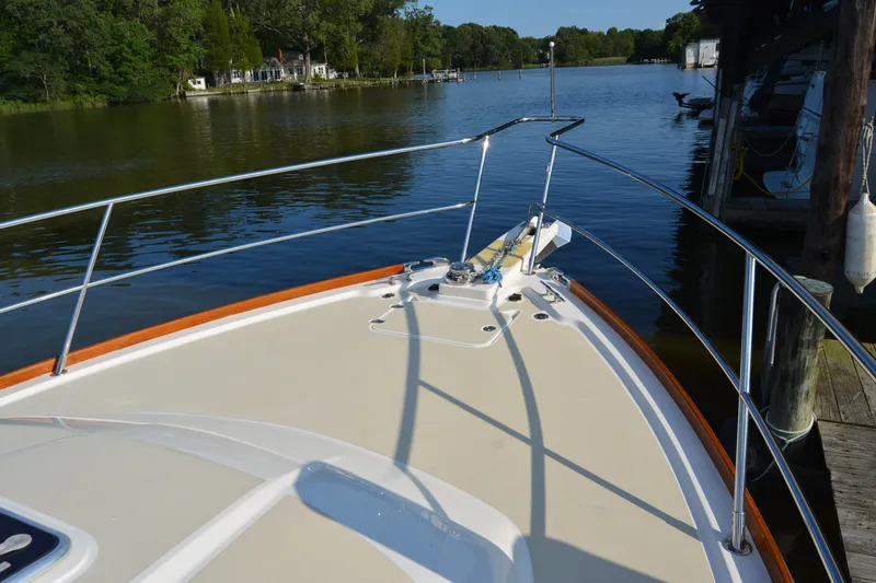 Slide: The Image of Bow of 2005 Sabre 38 Express yacht docked on a serene lake. - 7