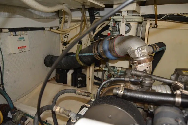 Slide: The Image of Engine room of a 2005 Sabre 38 Express boat, showcasing mechanical components and piping. - 107