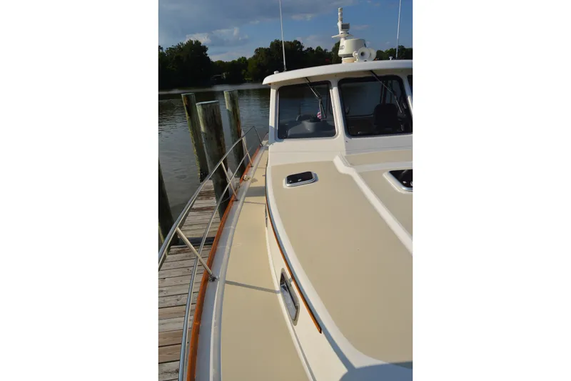 Slide: The Image of 2005 Sabre 38 Express yacht docked by a serene waterfront. - 15