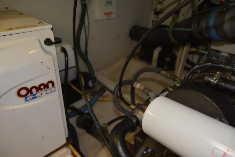 Slide: The Image of Engine room of a 2005 Sabre 38 Express with Onan generator and various hoses. - 108