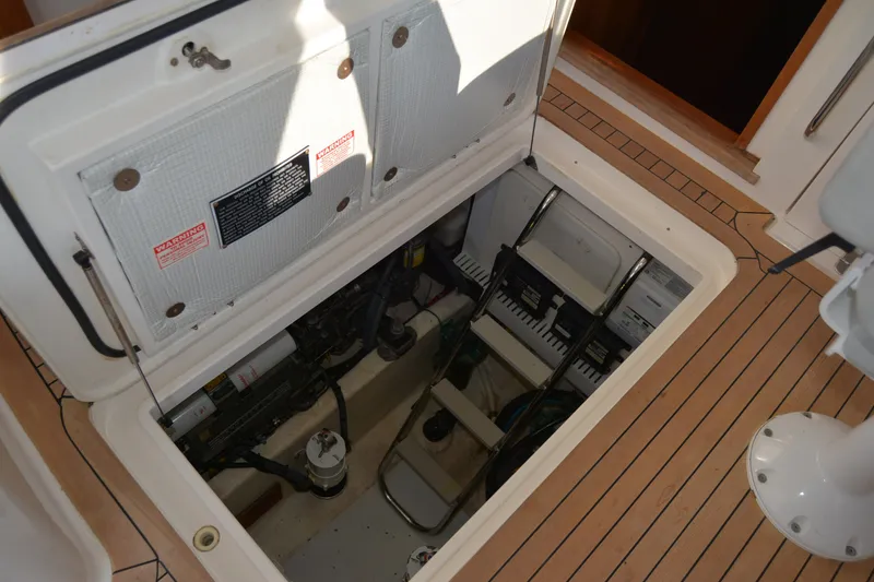 Slide: The Image of Engine compartment of a 2005 Sabre 38 Express boat, showcasing interior components and access ladder. - 94