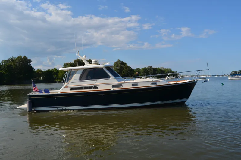 Slide: The Image of 2005 Sabre 38 Express yacht on calm water, under a clear blue sky. - 4